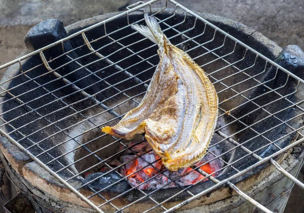 Grelhado peixe cabeça de cobra seca em carvão quente vermelho no fogão — Fotografia de Stock