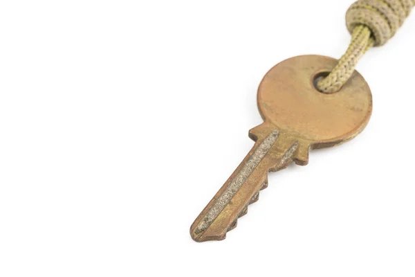 Old brass key with key chain on white background — Stock Photo, Image