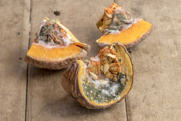 Moldy pumpkin on wooden table — Stock Photo, Image