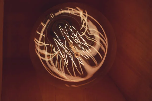 Quemando una lámpara incandescente con una gran espiral decorativa — Foto de Stock