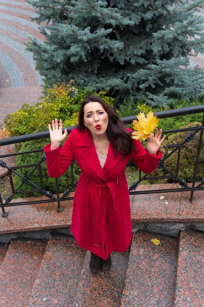 Hermosa mujer en un abrigo rojo expresa las emociones vívidas. Peop. — Foto de Stock