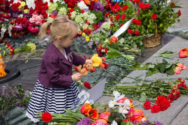 Kiev, Ukrayna - 9 Mayıs 2015: Kız Dünya Savaşı düşmüş asker Anıtı, bir oyuncak tutar