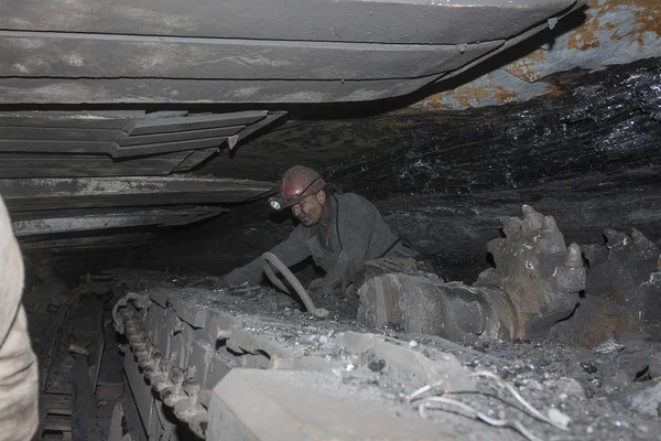Donieck, Ukraina - 16 sierpnia 2013: Górnik w pobliżu kombajnu górnictwa węgla. Kopalnia jest o nazwie Chelyuskintsev — Zdjęcie stockowe