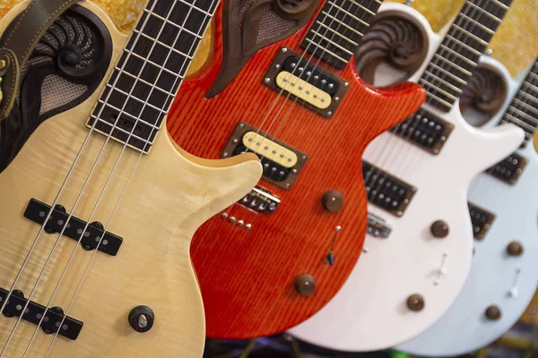 Många färgglada elgitarrer linje i en butik showroom — Stockfoto