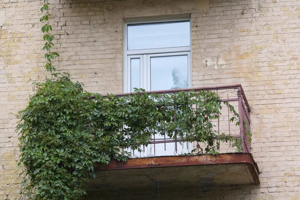 Old rusty balcony and modern plastic window