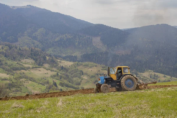 Gammal traktor plöjer mark i högländerna. Jordbruk — Stockfoto