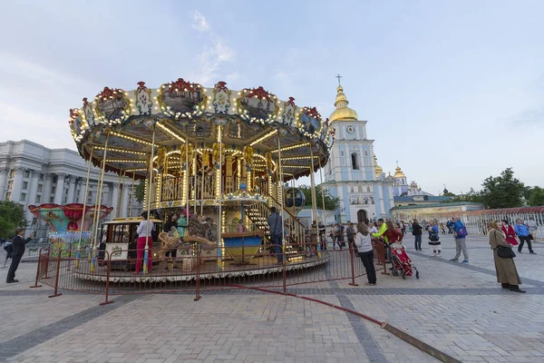 Kiev, Ucrânia - 03 de maio de 2016: As pessoas andam no carrossel instalado na Praça de São Miguel para celebrar a Páscoa — Fotografia de Stock
