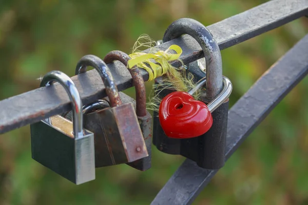 Red heart-shaped lock are hanging on the bridge lovers — Stock Photo, Image