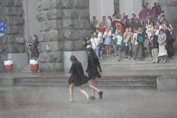 Kiev, Ukraine - May 27, 2016: Girls go without an umbrella in the pouring rain along Khreshchatyk Street — Stock Photo, Image