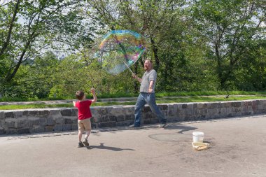 Kiev, Ukrayna - 04 Haziran 2016: Street Sanatçı genel parkta büyük renkli sabun köpüğü darbeler