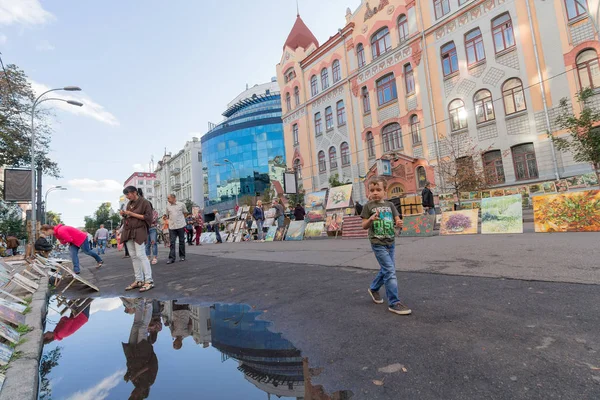 Kiev, Ucrania - 24 de agosto de 2016: Los artistas ponen pinturas para la venta y transeúntes en la calle. Vladimirskaya — Foto de Stock