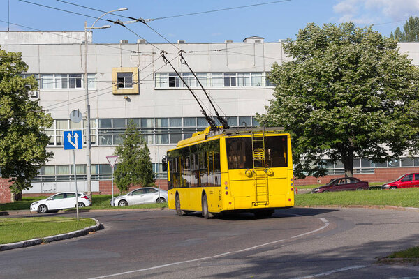 Yellow trolleybus on a city street. Transport