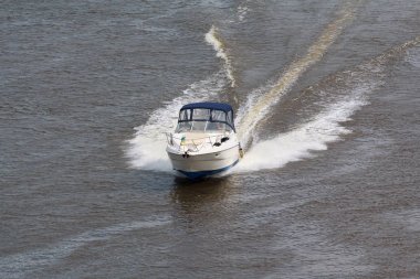 Nehri boyunca yüksek hızda bir motorlu tekne yelken. Taşıma