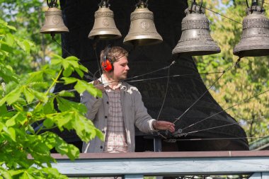 Kiev, Ukraine - May 05, 2016: Bell-ringer play on the set of bells of Holy Trinity Monastery of St. Jonas clipart