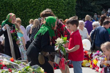 Kiev, Ukrayna - 09 Mayıs 2016: büyükannesi - yıldönümü kutlamaları, İkinci Dünya Savaşı gazilerinden çiçek veren çocuk