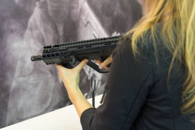 Bir otomatik silah sayaç elinde olan kız. Silah