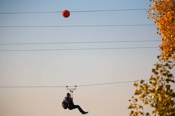 Male descend on a rope across the river — Stock Photo, Image