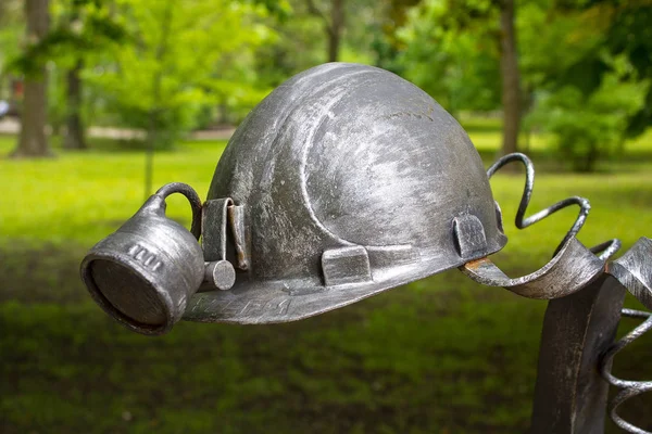 Donetsk, Ukraine - May 09, 2017: Miner's helmet forged figures forged from metal in the park — Stock Photo, Image