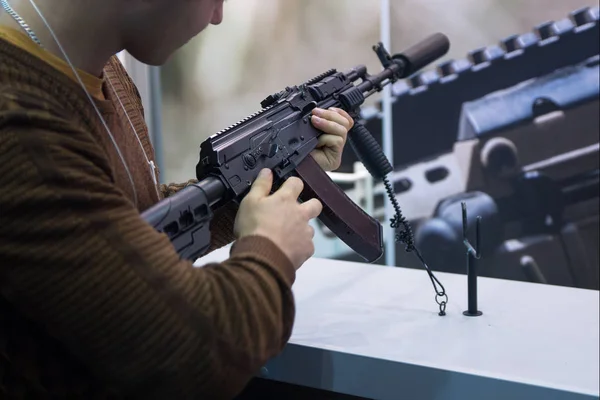 Un uomo con un fucile automatico al bancone. Armi — Foto Stock