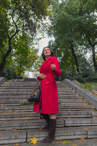 Mulher bonita com um casaco vermelho nas escadas. Pessoas — Fotografia de Stock