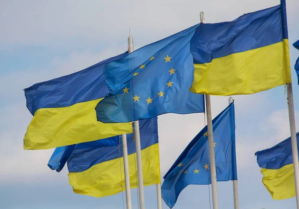 Σημαίες της Ουκρανίας και της Ευρωπαϊκής Ένωσης αναπτύσσονται ενάντια σε το φόντο του ουρανού — Φωτογραφία Αρχείου