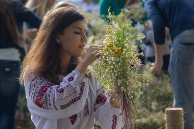 Kiev, Ukraine - July 06, 2017: Girl wreathes a wreath of herbs and flowers at the festival in honor of the national holiday of Ivan Kupala clipart