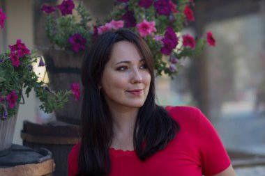 Güzel kadını bir çiçek yatakta kırmızı bir bluz. İnsanlar