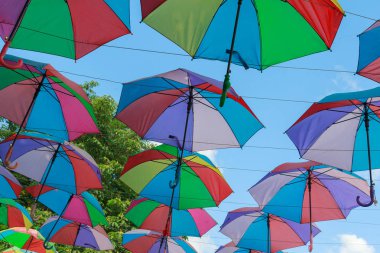 Kafe üzerinde gökyüzünde asılı rengarenk şemsiyeler