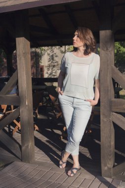 Güzel bir kadın tarafından bir ahşap çardak duruyor. İnsanlar