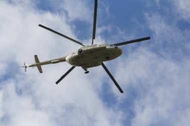 Helikopter bir mavi gökyüzü arka planda uçar. Taşıma