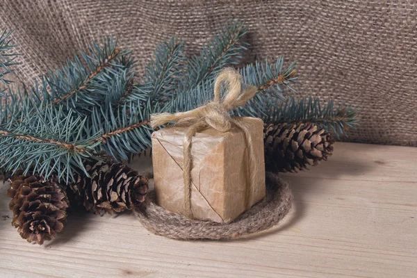 Hadiah dalam gaya retro dan pohon Natal dengan kerucut di permukaan kayu — Stok Foto