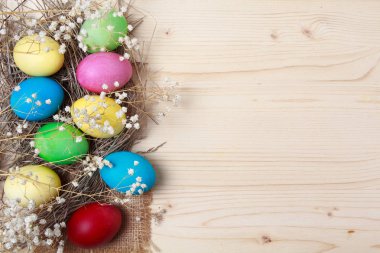 Bir ahşap yüzeyde çok renkli Paskalya yumurtaları. Tatil
