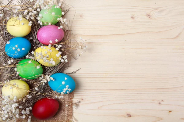 Bir ahşap yüzeyde çok renkli Paskalya yumurtaları. Tatil