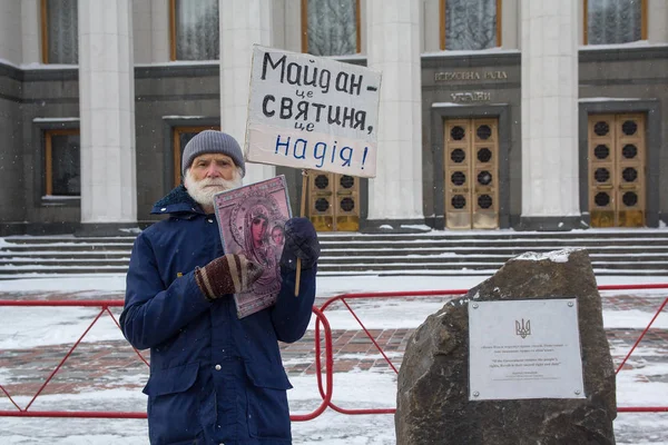 Киев, Украина - 04 марта 2018 года: Пожилой человек в одиночном пикете возле Верховной Рады с иконой и плакатом. На плакате надпись: "Майдан - это святыня, это надежда" в Украине — стоковое фото