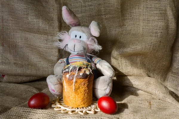 Toy rabbit, Easter cake and color eggs on a table. Easter — Stock Photo, Image