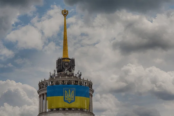 Oekraïense vlag op de voorkant van het gebouw met de ster, die werd gebouwd in de tijd van de Sovjet-Unie. Kiev, Oekraïne — Stockfoto