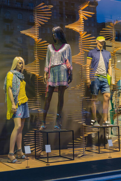 Mannequins in a shop window and a reflection of the city