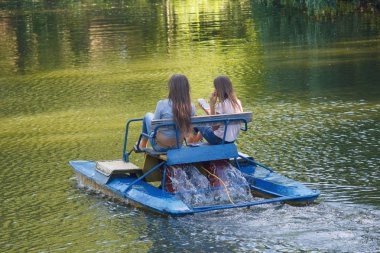 İki kız gölde katamaran binmek. Tatil