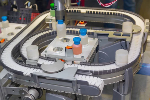 Robot works on a conveyor for the production of medical drugs. Industry