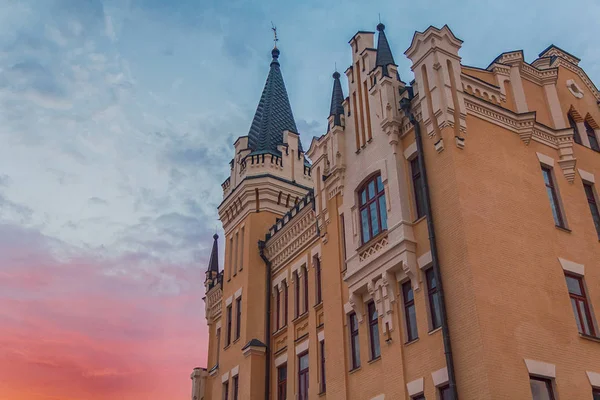 Schönes Gebäude im klassischen Stil mit Türmen im Hintergrund bei Sonnenuntergang. Kiew, Ukraine — Stockfoto