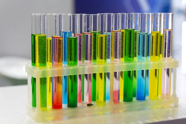 Sticlă de laborator cu soluții de diferite culori pe masă. Știință — Fotografie, imagine de stoc