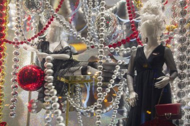 Dükkan penceresinde lüks bir kıyafet içinde kadın manken. Moda