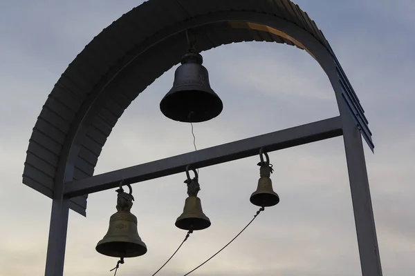 Silhouette of church bells against the evening sky. Religion — Stock Photo, Image