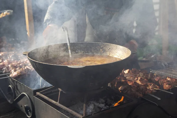 Metall gryta över en eld på gatan matfestival — Stockfoto