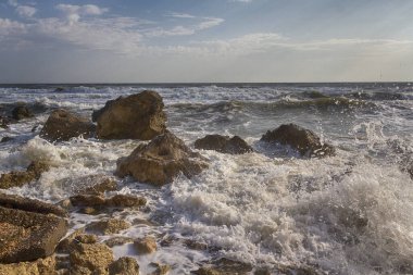 Dalgalar kayalar arasında sahilde yanılmak. Doğa