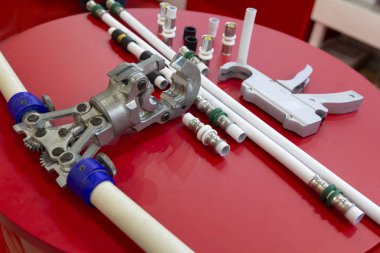 Su metali-plastik borular ve masadaki baskı aletleri. Sanayi