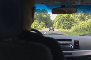 Direksiyonun ve yolun arkasındaki sürücünün arka görüntüsü ve dikiz aynası.