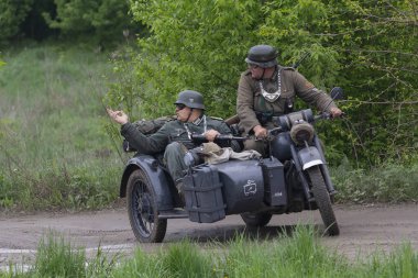 Kiev, Ukrayna - 09 Mayıs 2019: İkinci Dünya Savaşı'nda zafer yıldönümünde tarihi yeniden yapılanma bir motosiklet üzerinde Alman askerlerinin giysisi Erkekler