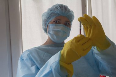 Koruyucu giysili kadın doktor ve laboratuarda maske. İlaç.