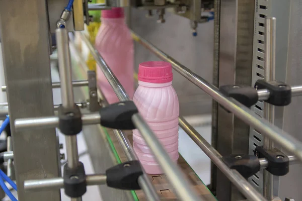 Plastic milk bottles on the conveyor on a modern dairy plant. Food industry